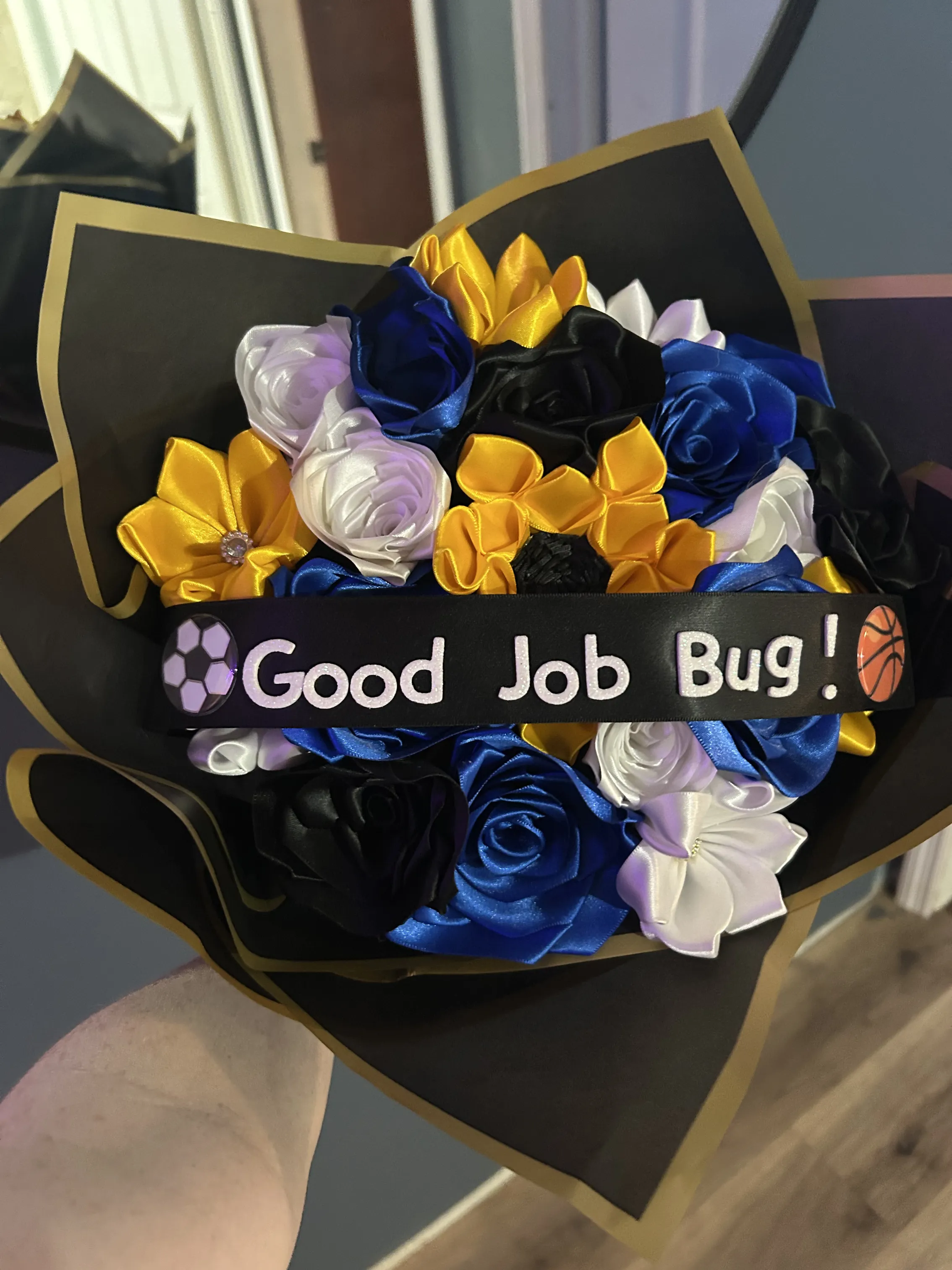 Blue, yellow, black and white ribbon rose bouquet with soccer and basketball icons and Good Job Bug ribbon