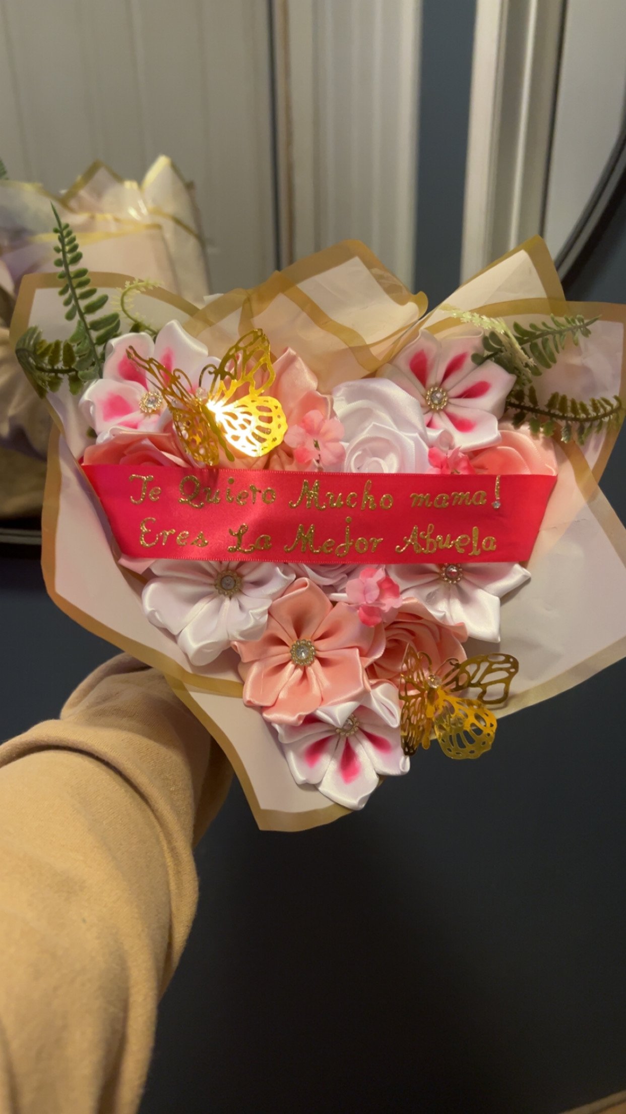 Pink and white ribbon flower bouquet with Te Quiero Mucho Mama ribbon and gold light-up butterflies